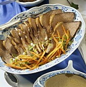 Sliced Sauerbraten (braised, marinated meat) with root vegetables