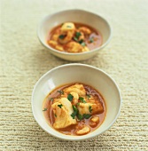 Pumpkin and coconut soup with chicken in two bowls