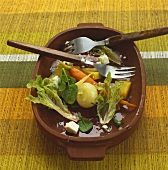 Half-eaten root vegetable salad in wooden bowl