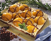 Chocolate nut cake topped with whipped cream and apricots