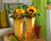 Sunflowers, tagetes and grasses in tall vases