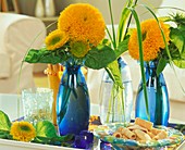 Gefüllte Sonnenblumen in blauen Vasen auf Tablett