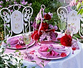 Gedeckter Tisch mit Pfingstrosen und Flieder dekoriert