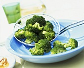 Broccoli florets on straining spoon