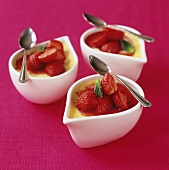 Crème caramel with strawberries in three small pots
