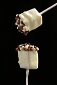Two white chocolate lollipops with tiny chocolate balls