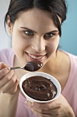 Young woman eating chocolate dessert