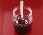 Cherry jam in jar and on spoon
