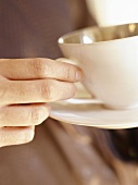 Hand Grabbing a Cup of Coffee by the Handle