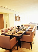 Long set dining table and armchairs in pale dining room