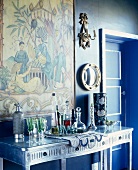 Silberner Wandtisch in blauem Zimmer mit großer chinesischer Szene an der Wand