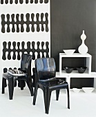 Black plastic chairs in front of black and white wallpaper