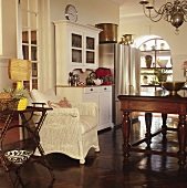 Dining room in mixture of styles with traditional furnishings, collectors' items and modern kitchen appliances with stainless steel fronts