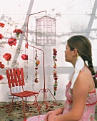 Girl in front of chair and birdcage