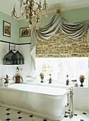 Prunkvolles Badezimmer mit edlem Kronleuchter und dekorativ drappiertem Store