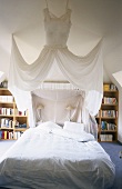 A four-poster bed and book case