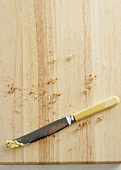 Bread crumbs and a knife on a board
