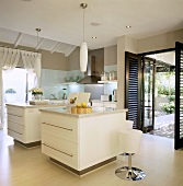 Moderne Küche mit zwei Kochblöcken vor offenen Terrassentüren