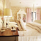 Romantic bedroom with floral wallpaper, bed & bedside cabinet