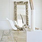 Two designer chairs and mirror on wall