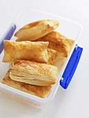 Several filled puff pastries in a freezer box