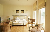 Ruhiges Schlafzimmer mit vielen Naturmateriealien, raumhohen Fenstern und Faltrollos