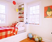 Cheerful child's bedroom with built-in bed frame, wall-mounted shelves and bright orange accents