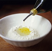 Adding oil to flour in a bowl