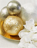 Goldene und silberne Weihnachtskugeln als Tischdekoration