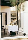 Dog lying next to table on roofed terrace