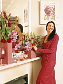 Woman arranging flowers on mantelpiece