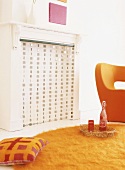 Die modernen Wohnzimmermöbel in knalligem Orange bilden einen effektvollen Kontrast zum umfunktionierten klassischen Kamin
