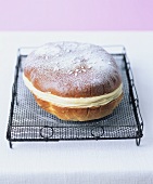 Yeast cake filled with vanilla cream on a cake rack