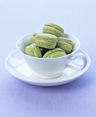 Green tea macarons in a cup and saucer