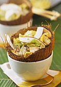 Wirsinggemüse mit Kokosstreifen in Kokosnuss angerichtet