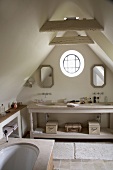 Uriges, kleines Badezimmer mit Rundfenster im Dachgeschoss eines Bauernhauses