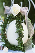 Easter decoration: ostrich egg with box, rose and bow