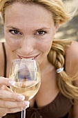 Blond woman drinking a glass of white wine