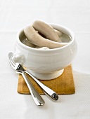 Cooked Weisswurst (white sausages) in a white tureen