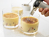 Zucker auf Crème brûlée mit Gas-Brenner karamellisieren