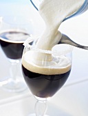 Cream being poured on to Irish coffee