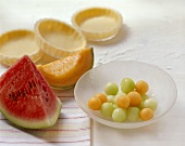 Backstilleben mit Melonen und rohen Torteletts