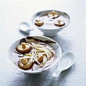 Asian rice noodles with mushrooms and spring onions in broth