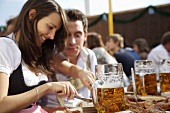 Mann & Frau in Tracht mit Schweinsbraten, Bier auf Volksfest