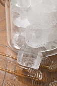 Ice cube with tongs and champagne bucket full of ice cubes