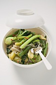 Noodles and vegetables in Asian soup bowl