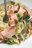 Ribbon pasta with fried peppered salmon (close-up)
