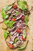 Seared tuna slices with tomatoes and beetroot leaves