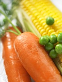 Fresh carrots, peas and corn on the cob (close-up)