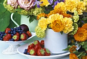 Jugs of flowers and fresh berries